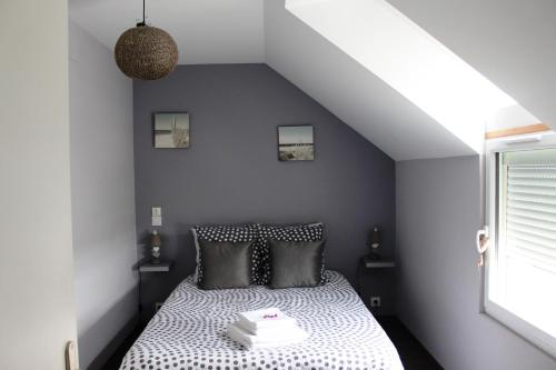 Aux Chambres du Mont في Huisnes-sur-Mer: غرفة نوم بسرير ولحاف ابيض