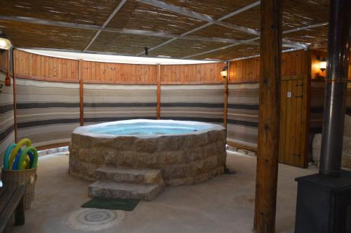 a room with a hot tub in a house at Shkutai Hottub Arava in Ẕofar