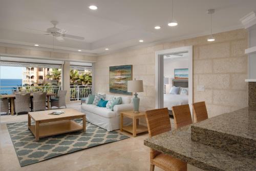 a living room with a white couch and a living room with a ocean view at The Crane Resort in Saint Philip