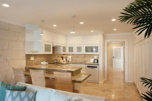 a kitchen with white cabinets and a counter top at The Crane Resort in Saint Philip