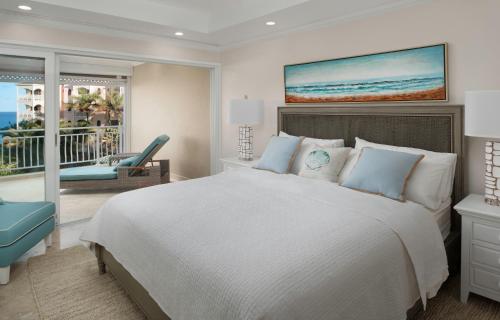 a bedroom with a large bed and a balcony at The Crane Resort in Saint Philip