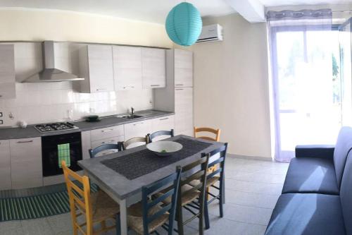 マリーナ・ディ・ジョイオーザ・イオーニカにあるAppartamento Vacanzeのキッチン(テーブル、椅子付)