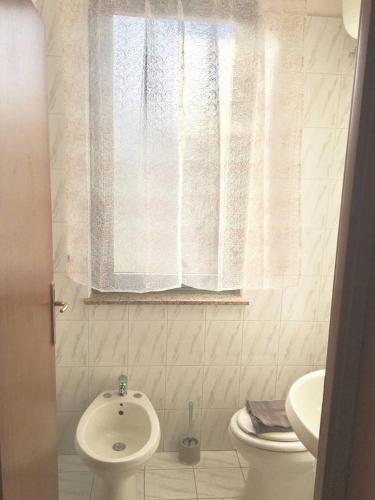 マリーナ・ディ・ジョイオーザ・イオーニカにあるAppartamento Vacanzeのバスルーム(トイレ、洗面台付)、窓が備わります。