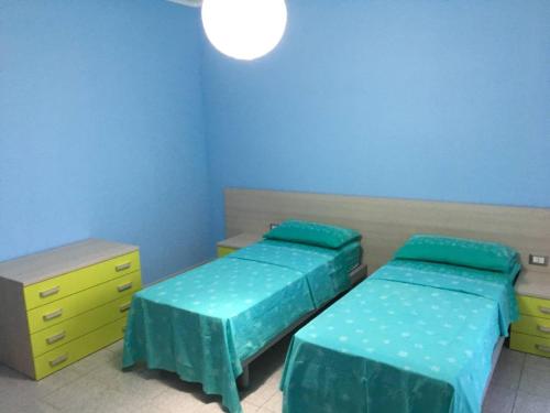 マリーナ・ディ・ジョイオーザ・イオーニカにあるAppartamento Vacanzeのベッド2台と黄色のドレッサーが備わる客室です。