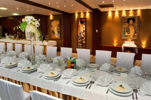 a long table with white tablecloths and napkins at Hotel Aros in Tychy