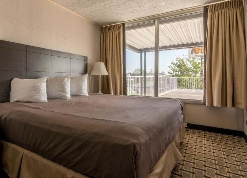 a bedroom with a large bed with a large window at Fiddlers Inn Opryland in Nashville