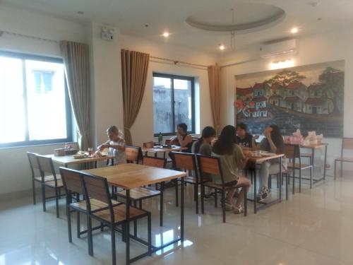 a group of people sitting at tables in a restaurant at Anova Airport Hotel - Convenient & Friendly in Noi Bai