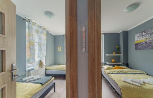 pokój z 3 łóżkami i drzwiami w obiekcie Apartament Grosik w mieście Duszniki Zdrój
