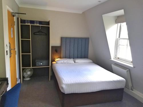 ロンドンにあるガーデン コート ホテルのベッドルーム(大型ベッド1台、窓付)