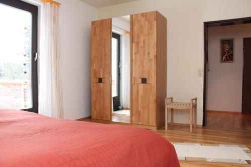 a bedroom with a red bed and a mirror at Ferienwohnung Wölfel in Schwarzenbach an der Saale