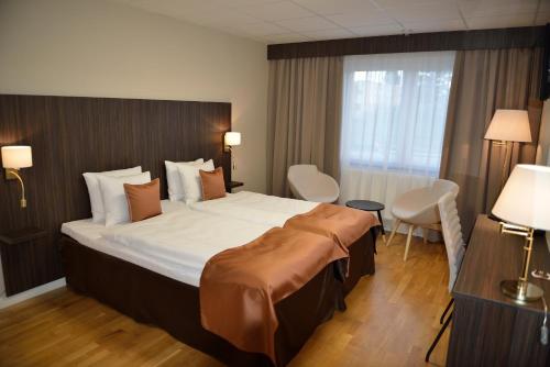 um quarto de hotel com uma cama grande e uma janela em Hotell Nova em Karlstad