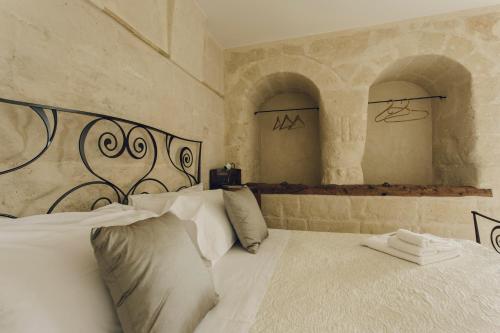 1 dormitorio con 1 cama grande con sábanas blancas en Casastella, en Matera