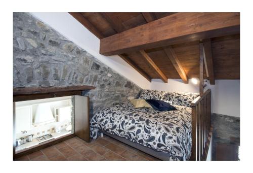 ein Schlafzimmer mit einem Bett und einer Steinmauer in der Unterkunft Il Borgo di Tresana Casa Marina in Tresana