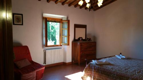 a bedroom with a bed and a dresser and a window at Colonica Montebeni in Greve in Chianti