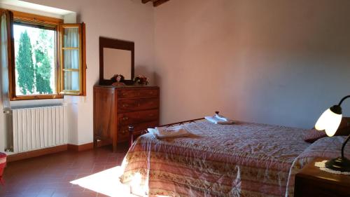 a bedroom with a bed and a dresser and a mirror at Colonica Montebeni in Greve in Chianti