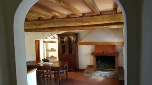 a dining room with a table and a fireplace at Colonica Montebeni in Greve in Chianti