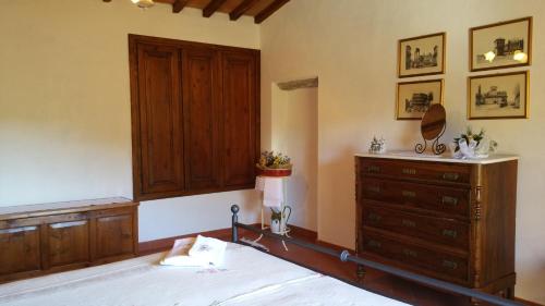 a bedroom with a bed and a dresser at Colonica Montebeni in Greve in Chianti