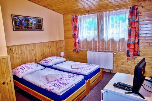 a bedroom with two beds and a computer on a desk at Penzion Radošov ubytování v soukromí in Kysibl Kyselka