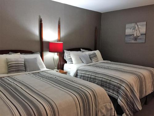a bedroom with two beds and a red lamp at Greenside Motel in Saint Andrews