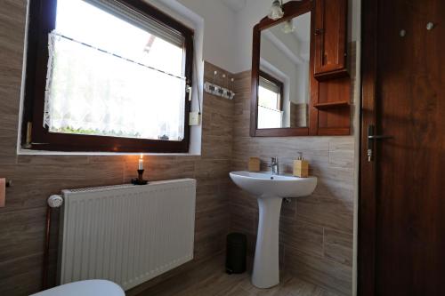 a bathroom with a sink and a window with a candle at Casa 193 in Sibiu