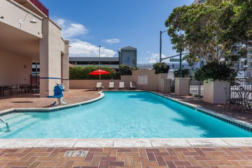 a swimming pool with a person walking around it at Ramada by Wyndham San Diego National City in National City