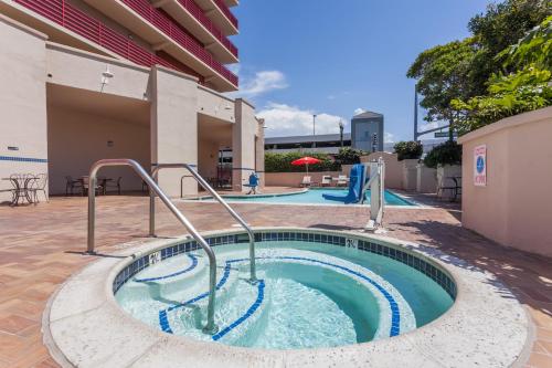 a pool with a hot tub in the middle of a building at Ramada by Wyndham San Diego National City in National City