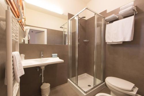 a bathroom with a toilet, sink, and shower at Hotel Delta in Montevarchi