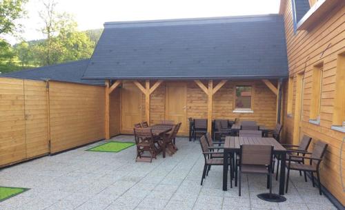 a patio with wooden tables and chairs and a building at Chalets under Falcon Ridge in Česká Ves