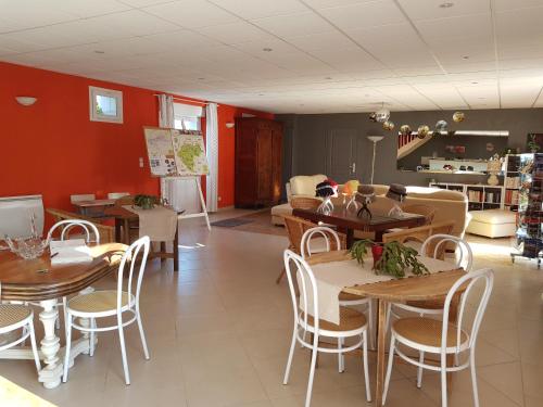 comedor con mesas y sillas de madera en chambres des rosiers, en Sennevières