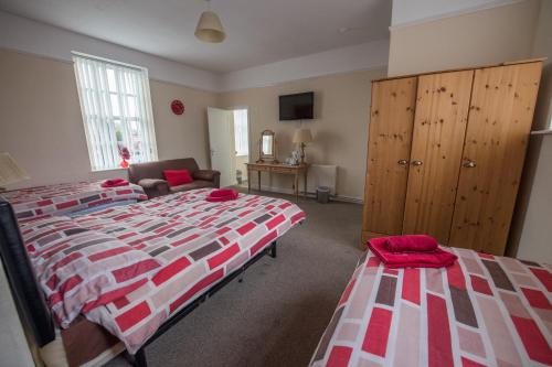 a bedroom with two beds and a dresser and a bed at The Rodney in Warrington