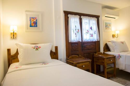 a bedroom with two beds and a door with a window at Monza House Otel in Siğacık