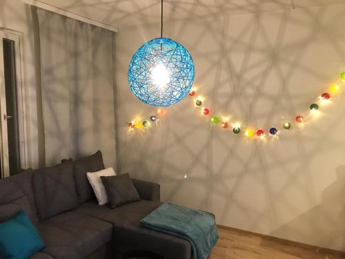 a living room with a couch and a blue chandelier at The Harbour Apartments in Jyväskylä