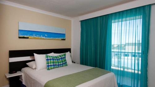 - une chambre avec un lit et une grande fenêtre dans l'établissement LD Suites Punta Playa, à Altagracia
