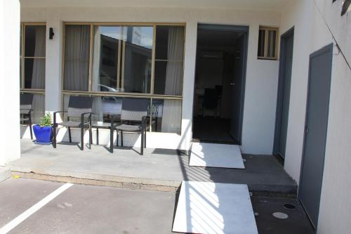 a patio with a table and chairs on a building at Zorba Waterfront Motel in Batemans Bay