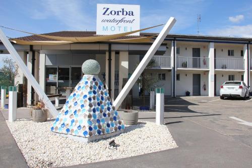 a sculpture of a person in a dress in front of a motel at Zorba Waterfront Motel in Batemans Bay