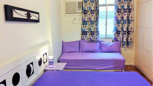 un sofá púrpura en una habitación con ventana en Apartamento Lausanne en Río de Janeiro