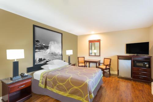 a hotel room with a bed and a flat screen tv at Super 8 by Wyndham Martinez in Martinez