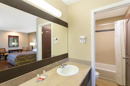 a bathroom with a sink and a room with a bed at Super 8 by Wyndham Martinez in Martinez