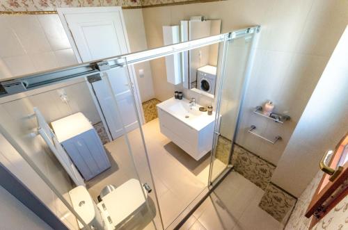 een badkamer met een glazen douche en een wastafel bij Leo - Unique Glyfada Apartment in Athene