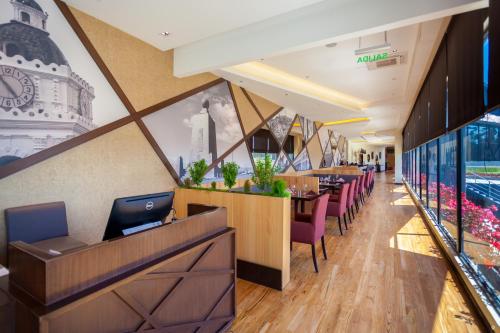 a restaurant with a bar with purple chairs at Wyndham Quito Airport in Tababela