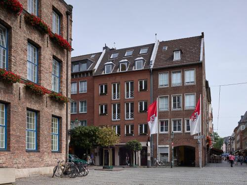 un groupe de bâtiments arborant des drapeaux devant eux dans l'établissement Apartment-Hotel am Rathaus, à Düsseldorf