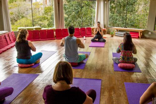 a group of people sitting in a yoga class at Buzios Espiritualidade Hotel in Búzios