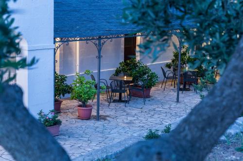 a patio with a table and chairs and plants at B&B Pozzo Di Luce - Adults only in Monopoli