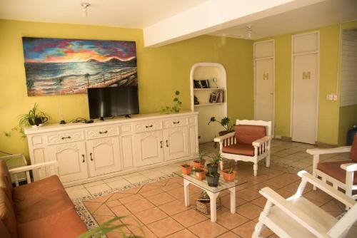 a living room with a flat screen tv on a wall at Hotel Esperanza in Mazatlán