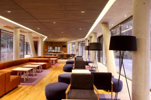 a lobby with couches and tables and chairs at Las Majadas Hotel & Centro de Reuniones in Pirque