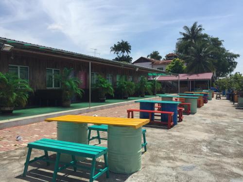 a row of tables and benches in front of a building at Mabohai Resort Klebang in Malacca