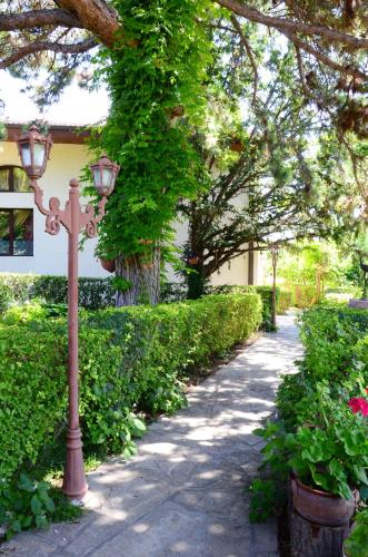 a street light next to a sidewalk with bushes at Dallas Residence in Varna City