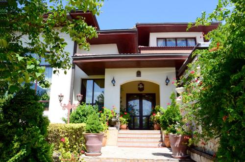 a house with a front door with plants and flowers at Dallas Residence in Varna City