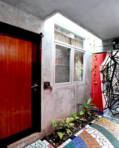 a red door of a house with a window at Phuket Paradiso in Chalong 