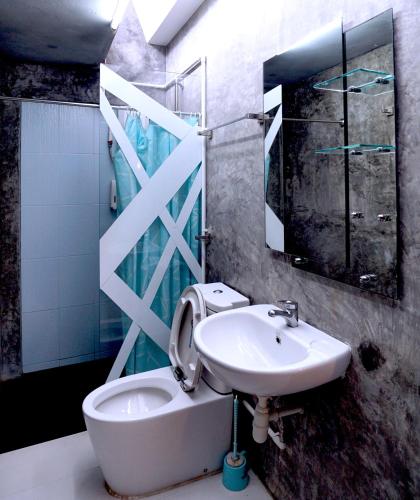 a bathroom with a sink and a toilet and a mirror at Phuket Paradiso in Chalong 